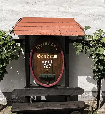 Fassboden mit der Aufschrift "Weindorf Genheim seit 767" heißt die Besucher am Ortseingang von Genheim willkommen